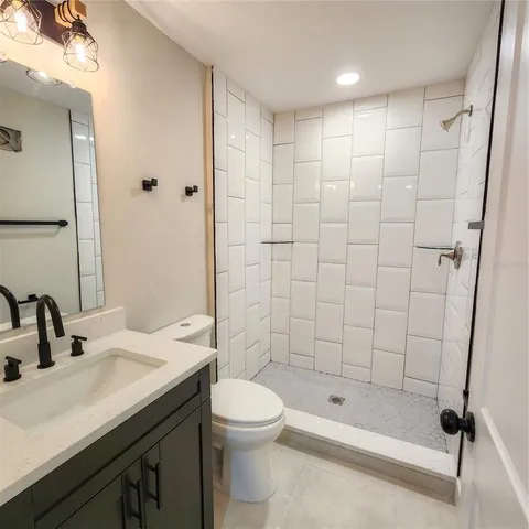a bathroom with a bathtub shower sink vanity and toilet