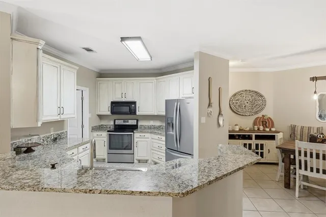 a kitchen with stainless steel appliances granite countertop a refrigerator a stove and a sink