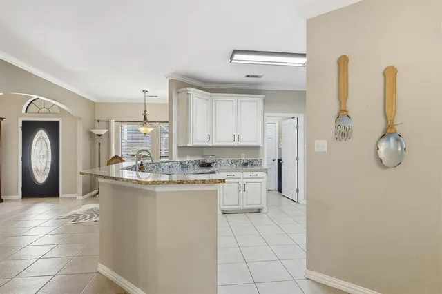 a kitchen with a sink a refrigerator and cabinets