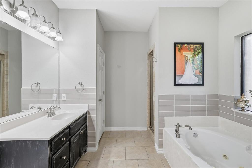 1805 Spinnaker Lane Azle, TX 76020 - Photo 22 of 40 a bathroom with a tub a sink and mirror