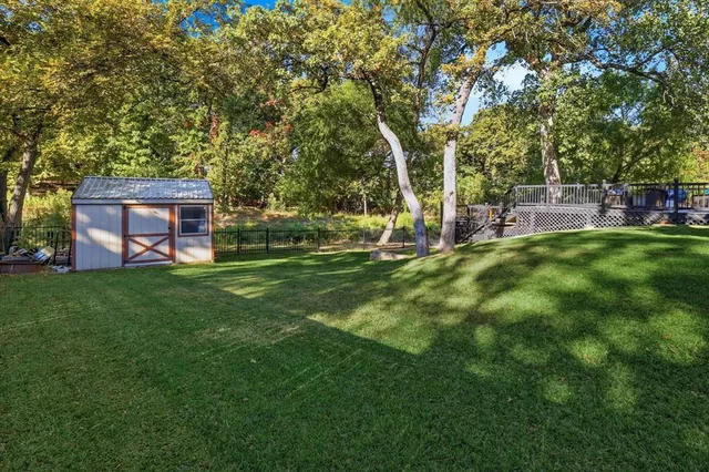 a view of a house with a big yard and large trees