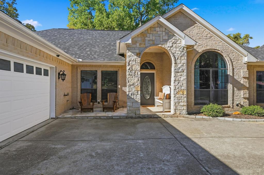 1805 Spinnaker Lane Azle, TX 76020 - Photo 4 of 40 a view of a white house with large windows and a table and chairs