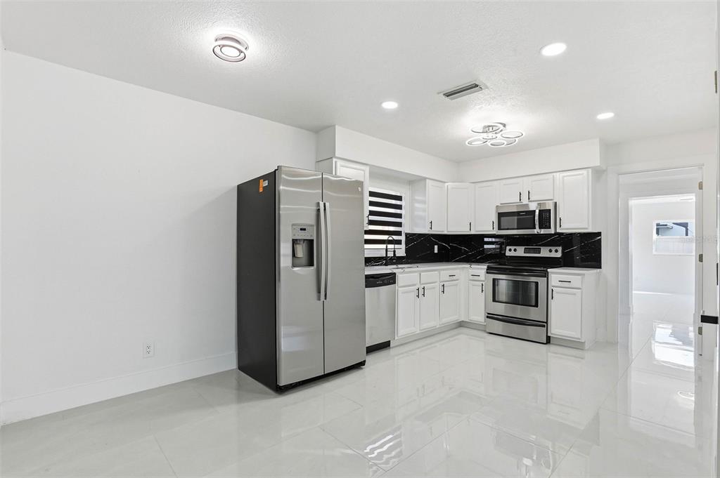 3216 West Beach Street Tampa, FL 33607 - Photo 37 of 63 a kitchen with stainless steel appliances a refrigerator and a stove top oven
