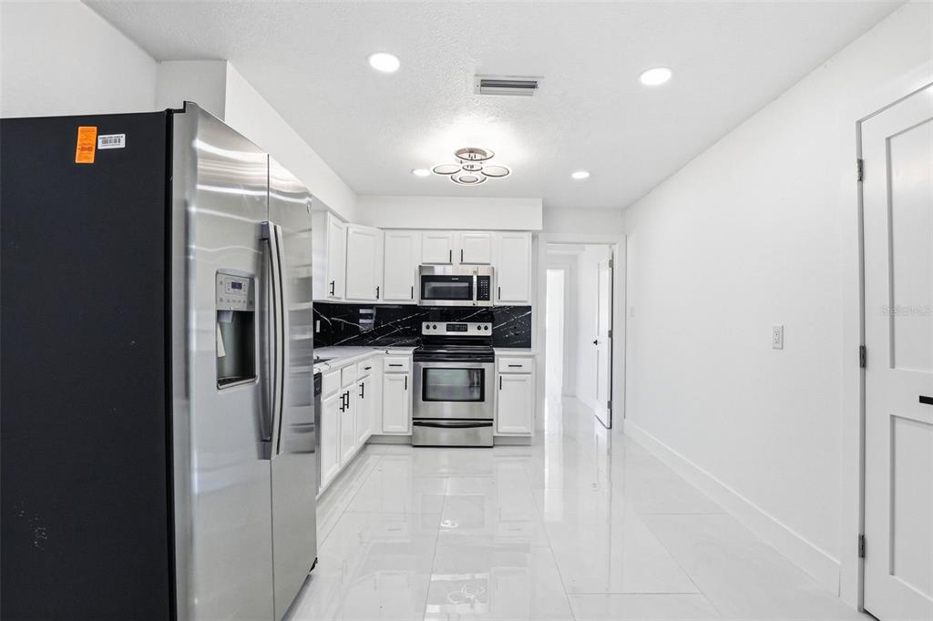 3216 West Beach Street Tampa, FL 33607 - Photo 40 of 63 a kitchen with stainless steel appliances a refrigerator sink and stove top oven