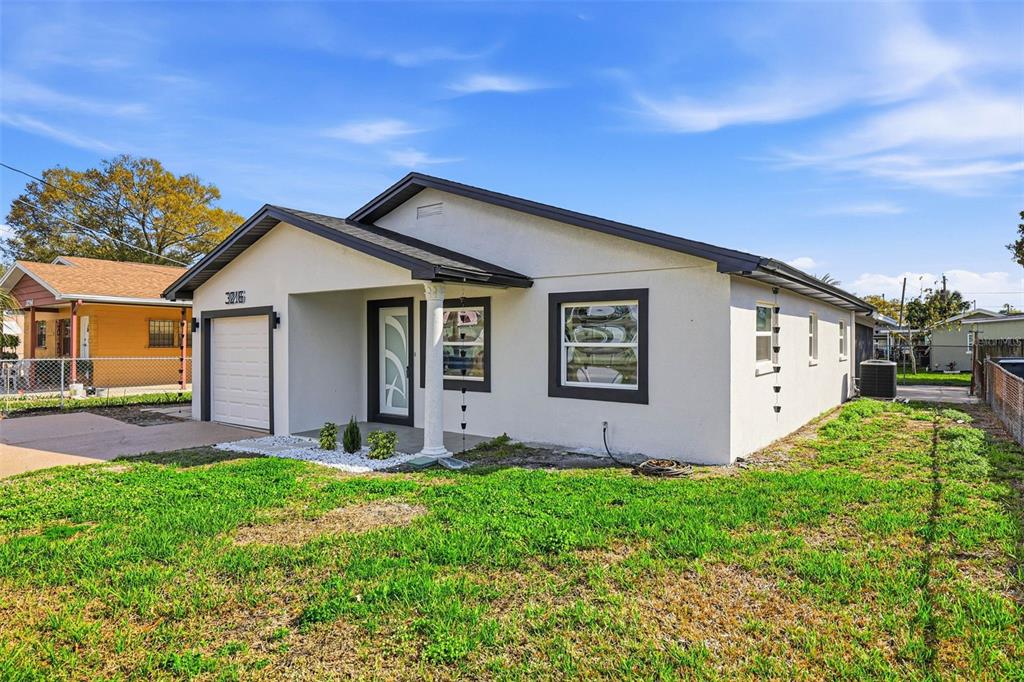 3216 West Beach Street Tampa, FL 33607 - Photo 8 of 63 a front view of a house with a yard and garage