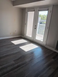 an empty room with wooden floor and windows