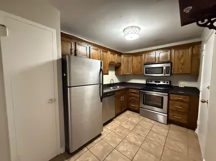 a kitchen with granite countertop a refrigerator stove and microwave