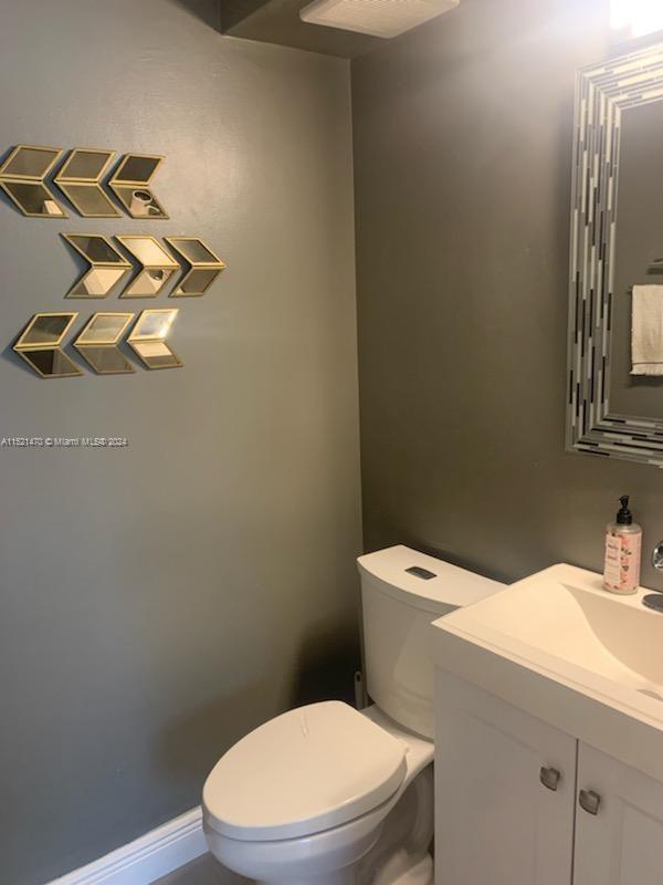4590 Southwest 68th Ct Circle, Unit 4 Miami, FL 33155 - Photo 13 of 32 a bathroom with a toilet sink and mirror