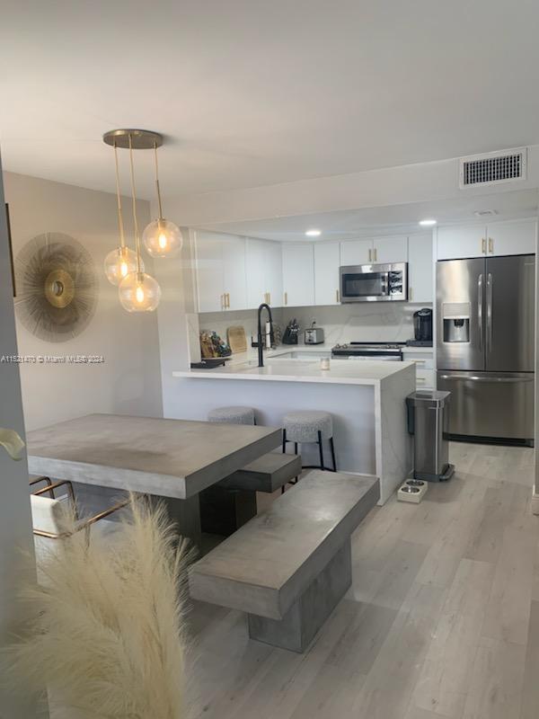 4590 Southwest 68th Ct Circle, Unit 4 Miami, FL 33155 - Photo 2 of 32 a kitchen with kitchen island granite countertop a sink a counter top space cabinets and stainless steel appliances