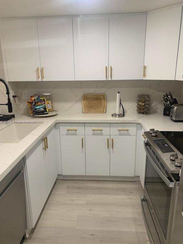 4590 Southwest 68th Ct Circle, Unit 4 Miami, FL 33155 - Photo 3 of 32 a kitchen with stainless steel appliances granite countertop a sink stove and cabinets