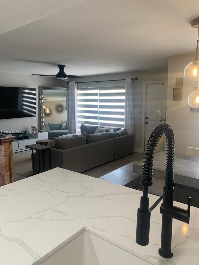 4590 Southwest 68th Ct Circle, Unit 4 Miami, FL 33155 - Photo 8 of 32 a kitchen with granite countertop a stove and white cabinets