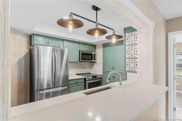 a kitchen with stainless steel appliances kitchen island a refrigerator and a sink