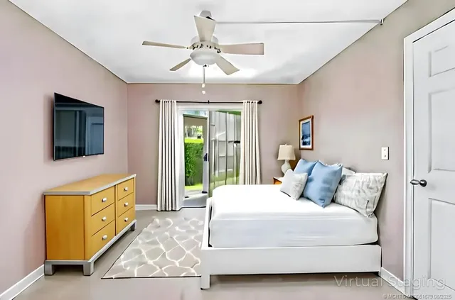 a bedroom with a large bed and a flat tv screen on dresser