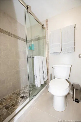 a white toilet sitting next to a shower