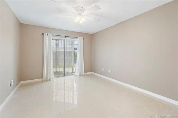an empty room with chandelier fan