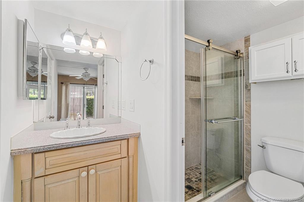 3218 Southeast Aster Lane, Unit P116 Stuart, FL 34994 - Photo 43 of 45 a bathroom with a granite countertop shower sink vanity and mirror