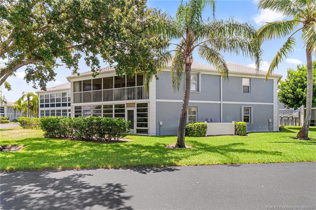 3218 Southeast Aster Lane, Unit P116 Stuart, FL 34994 - Photo 5 of 45 a view of a house with a yard and palm trees