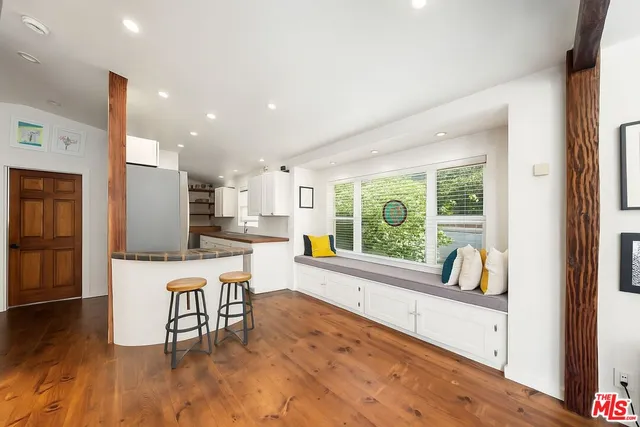 a kitchen with a table chairs refrigerator and cabinets