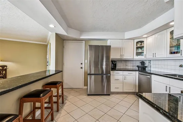a kitchen with granite countertop a stove top oven microwave and a sink