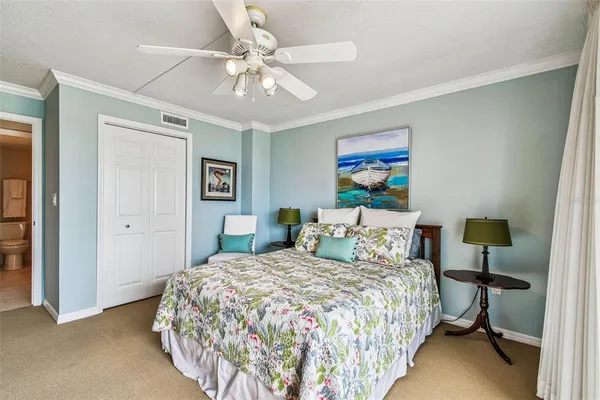 a bedroom with a large bed and a chandelier