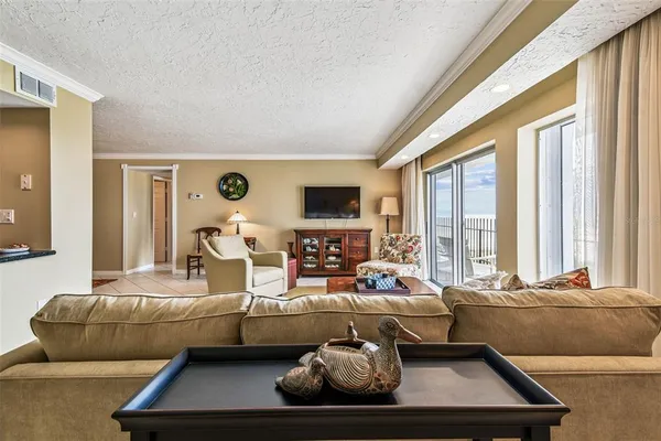 a living room with furniture a flat screen tv and a large window