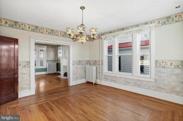 an empty room with wooden floor closet fan and windows