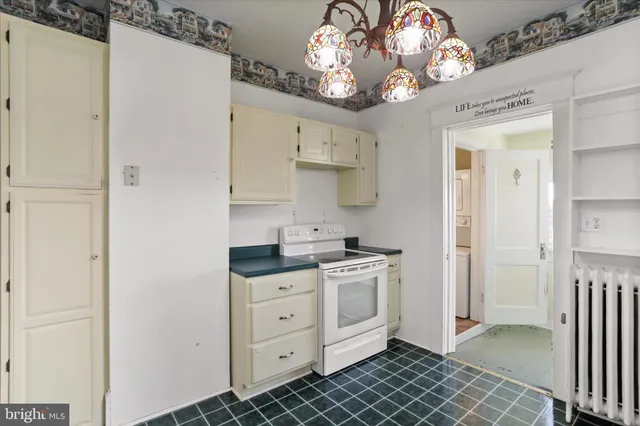 an empty room with wooden floor chandelier fan and closet area with wooden floor