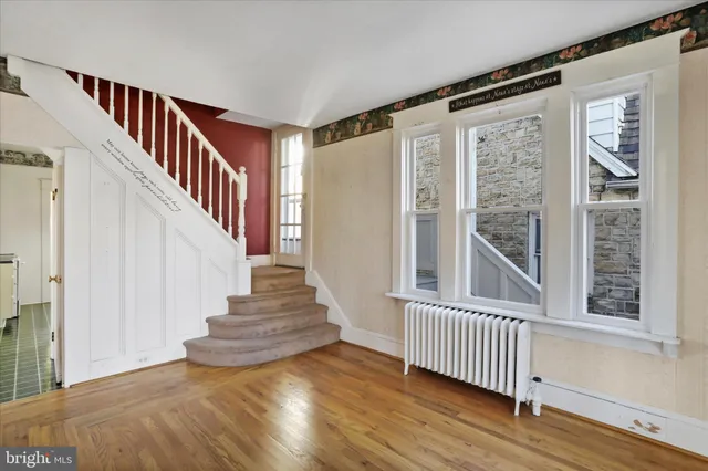 a view of a room with wooden floor chandelier and windows