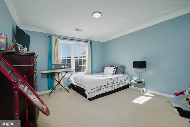 a bedroom with bed and a flat tv screen on dresser