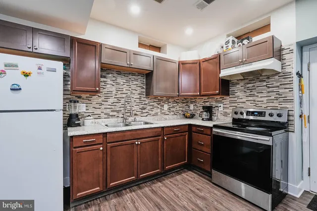 a kitchen with stainless steel appliances granite countertop a stove sink and cabinets
