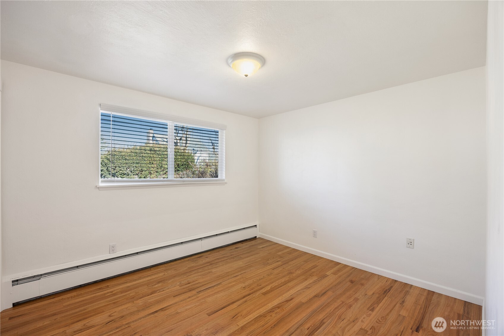 110 Linden Avenue Moses Lake, WA 98837 - Photo 18 of 40 an empty room with wooden floor and windows
