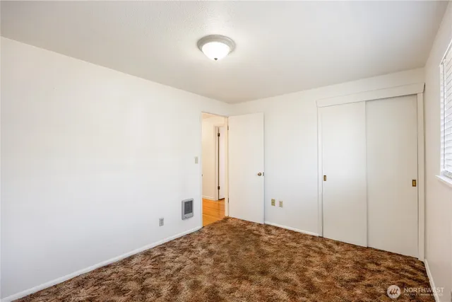an empty room with wooden floor cabinet and closet