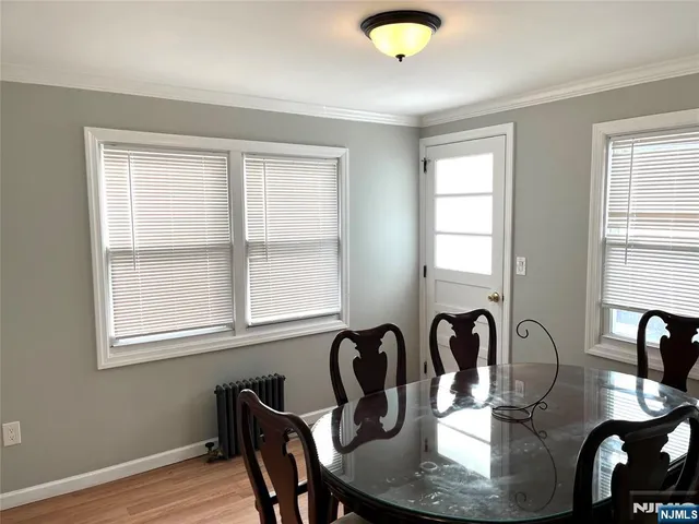 a view of a a dining room with furniture window and wooden floor