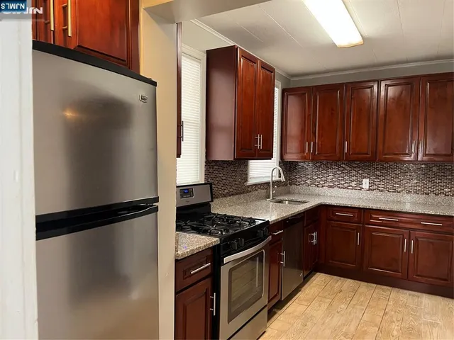 a kitchen with a refrigerator stove and cabinets