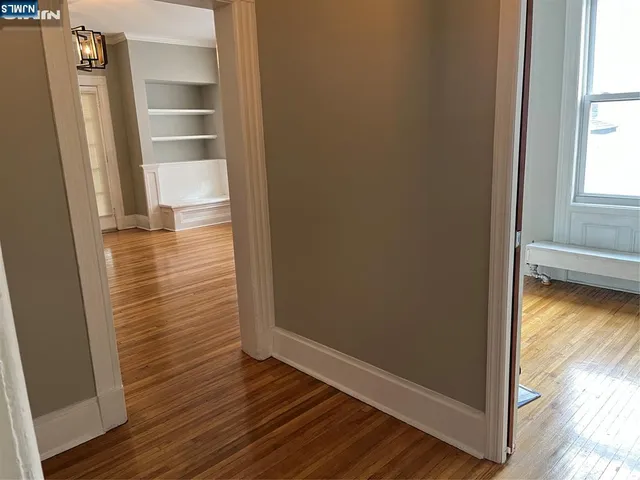 a view of a livingroom with wooden floor and a chandelier