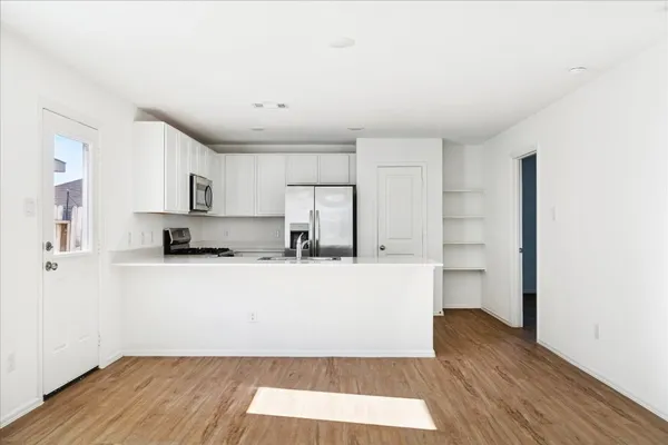 a living room with stainless steel appliances wooden floors and view living room