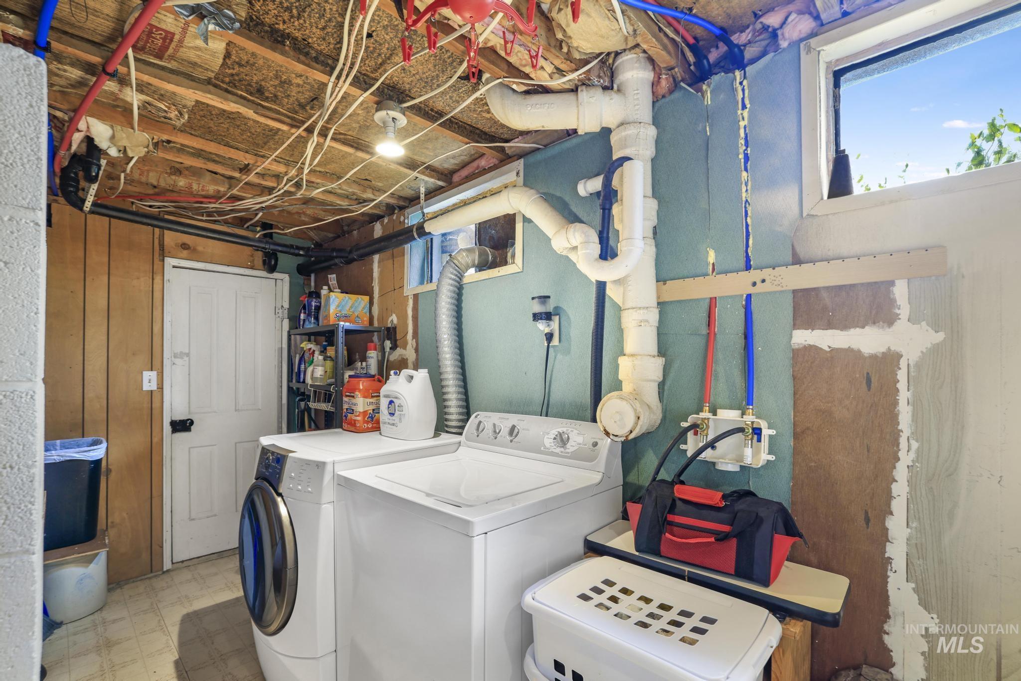 19591 Queen Crown Road Carey, ID 83320 - Photo 20 of 37 Laundry area featuring a side-by-side washer and dryer, utility sink, and window providing natural light