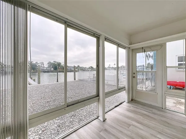 a view of an empty room with wooden floor and a floor to ceiling window