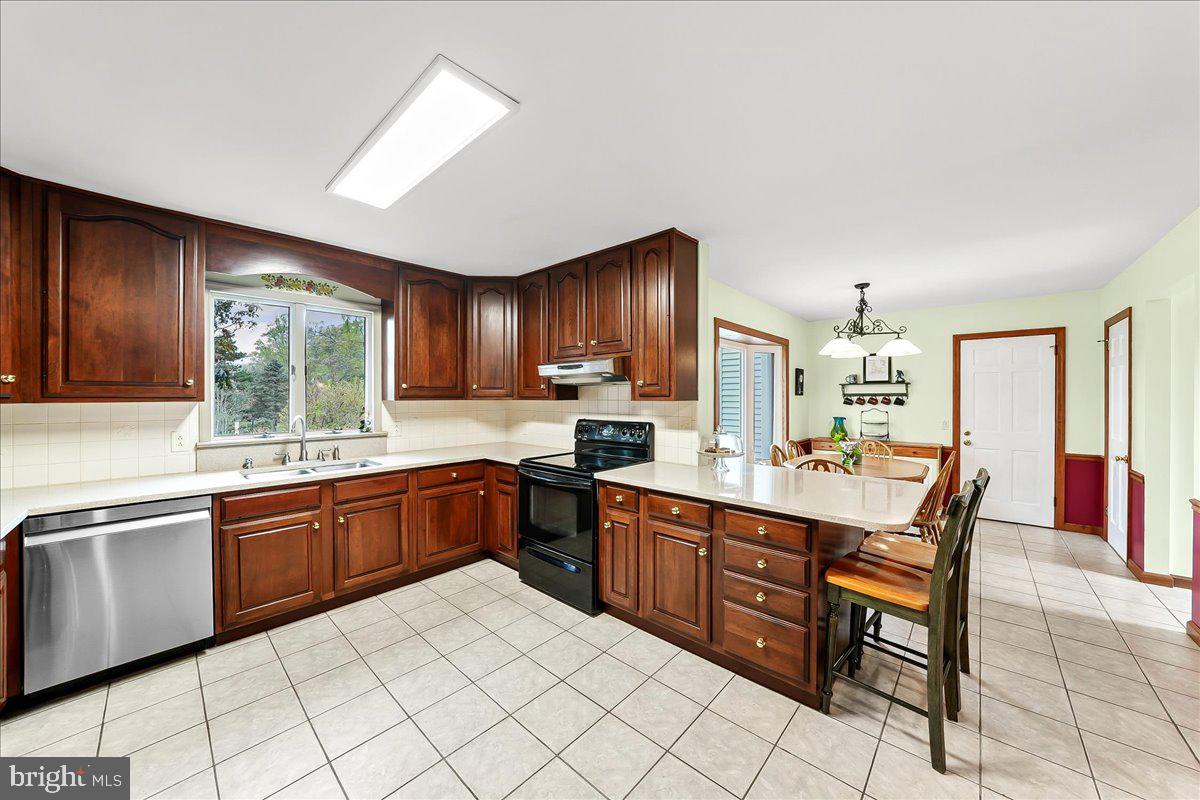 701 Pheasant Run Kennett Square, PA 19348 - Photo 13 of 41 a kitchen with stainless steel appliances granite countertop a stove sink and cabinets