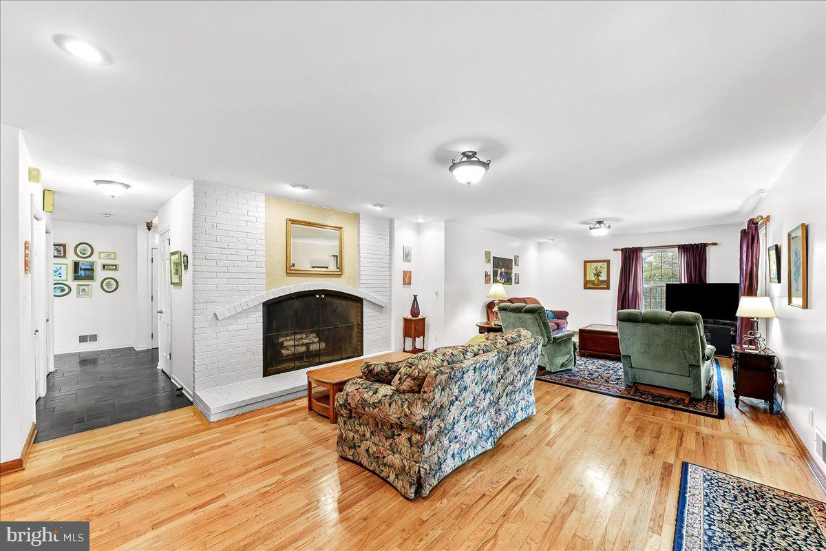701 Pheasant Run Kennett Square, PA 19348 - Photo 5 of 41 a living room with furniture a fireplace and a flat screen tv