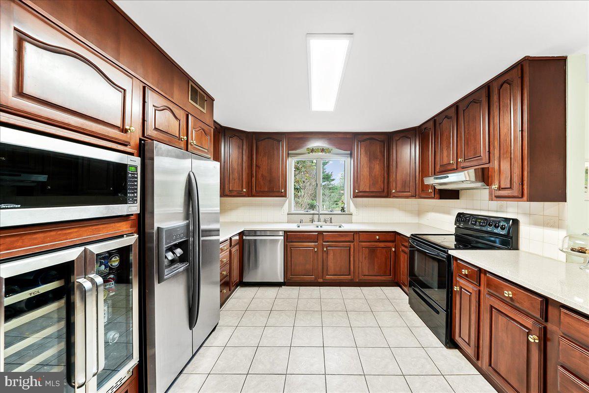 701 Pheasant Run Kennett Square, PA 19348 - Photo 6 of 41 a kitchen with stainless steel appliances granite countertop wooden cabinets a stove top oven a sink and dishwasher