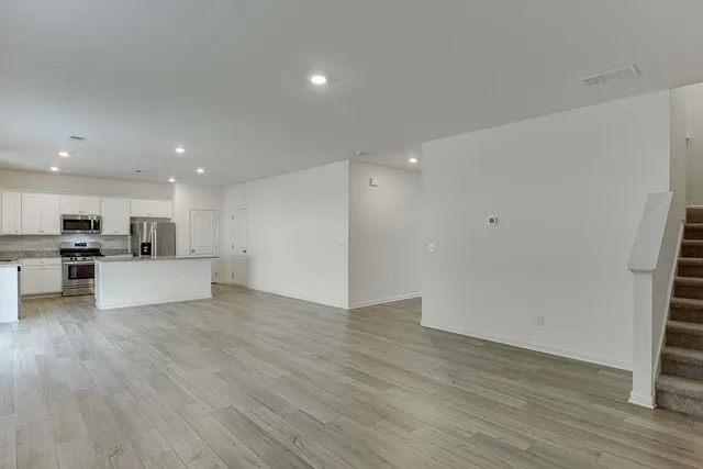a view of kitchen with kitchen island wooden floor and center island