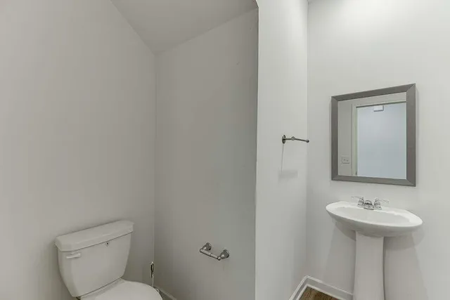 a bathroom with a sink toilet and a mirror
