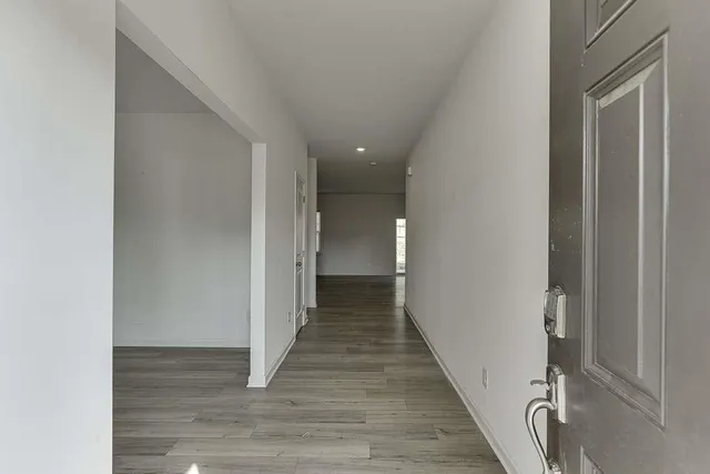 a view of a hallway with wooden floor