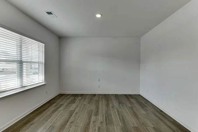 a view of a room with wooden floor and window