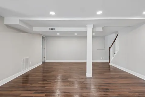 a view of an empty room with wooden floor