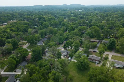 an aerial view of a forest with houses