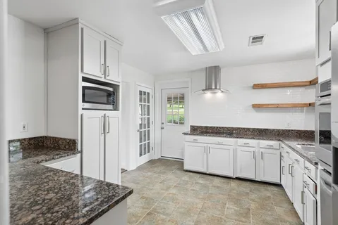 a kitchen with stainless steel appliances granite countertop a sink and cabinets