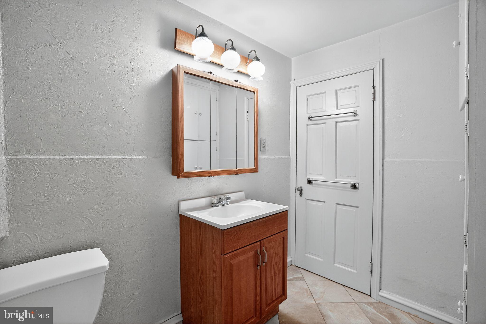 944 Galbraith Avenue Marcus Hook, PA 19061 - Photo 17 of 26 a bathroom with a toilet a sink a mirror and vanity