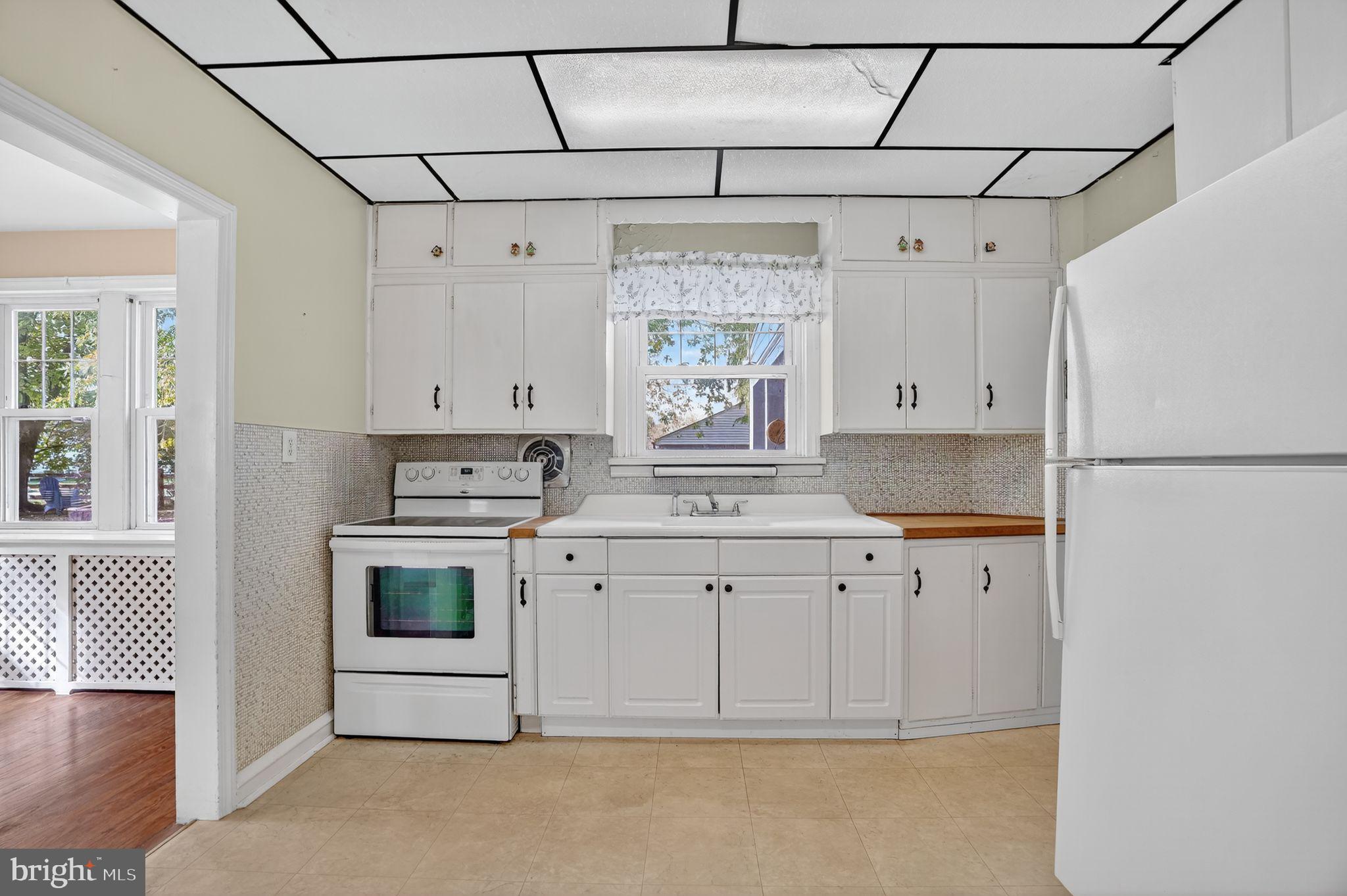 944 Galbraith Avenue Marcus Hook, PA 19061 - Photo 9 of 26 a kitchen with granite countertop a white refrigerator oven a sink and white cabinets